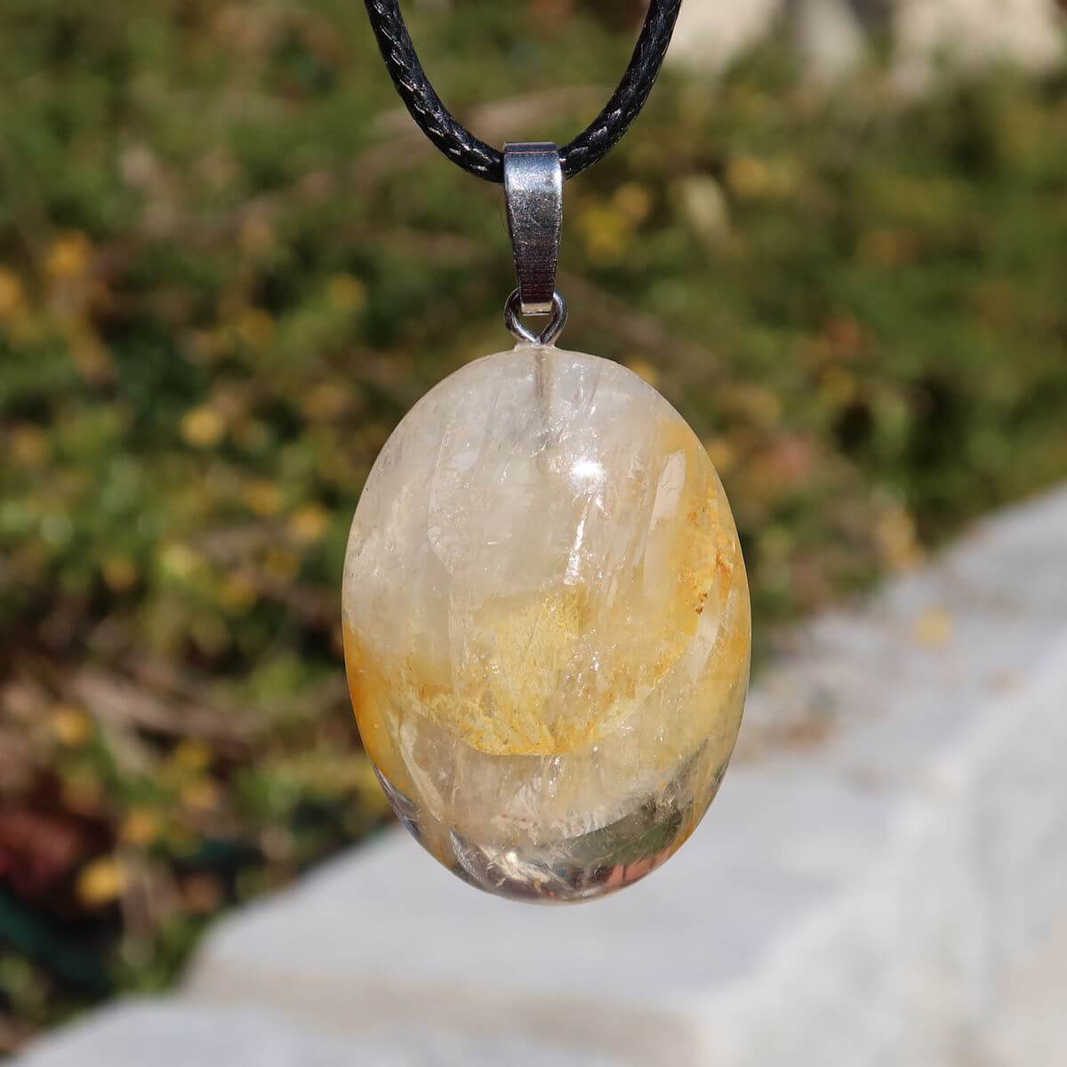 Limonit Quarz Golden Healer Anhänger - Lebensfreude - Nr. 13 mit funkelndem Quarz und goldbraunen Einschlüssen vor grünem Hintergrund