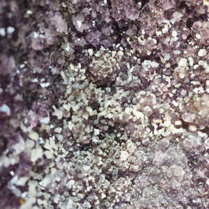 Close-up of an Amethyst druse showing sparkling purple and white crystal textures for harmonizing and relaxation spaces