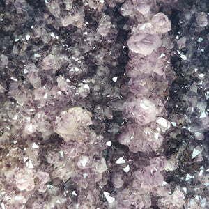 Close-up view of an Amethyst Geode showing sparkling purple crystals promoting harmony and transformation