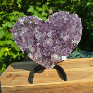 Amethyst Druse Amethyst Geode in Herzform mit Metallsockel 18x18x10cm - NR-7 auf einem Holzständer.