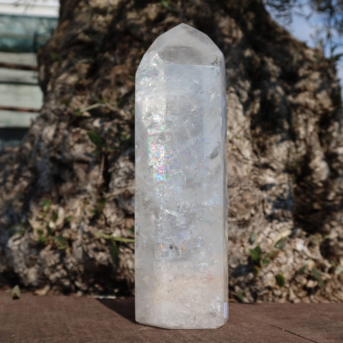 Bergkristall, Quarz, Obelisk geschliffen UNIKAT Nr. 8, transparentes Kristall mit Regenbogenreflexen auf natürlichem Hintergrund.