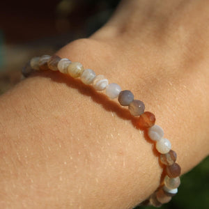Faceted agate gemstone bracelet with 4-6-8mm beads on wrist, featuring vibrant patterns and colors for style and protection.