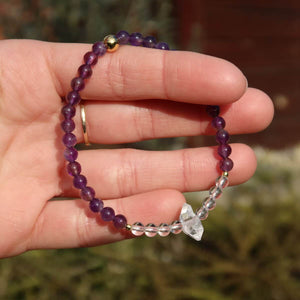 Hand holding handmade amethyst, bergkristall, and herkimer gemstone bracelet, 17cm long
