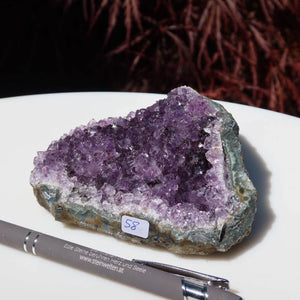 Amethyst Drusen in 1A Qualität mit violetter Kristallfläche, Unikat Nr. 58 aus Uruguay, auf weißer Fläche präsentiert.