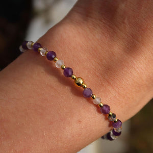 Handcrafted amethyst and tourmalinated quartz bracelet with faceted gemstone beads on wrist, 17cm long.