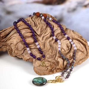 Mala Kette mit Labradorit und Amethyst auf Holz präsentiert, edle und harmonische Farben, Spiritualität und Intuition.