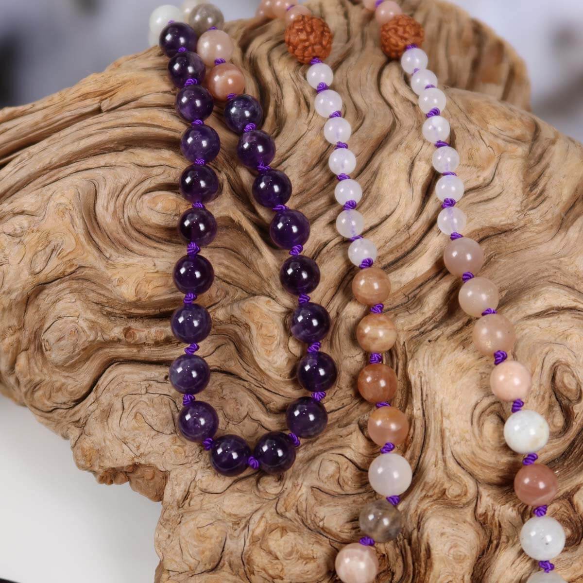 Mala Kette mit Amethyst Anhänger auf Holz, kombiniert mit Mondstein, Labradorit und Rudraksha für Harmonie und Transformation.
