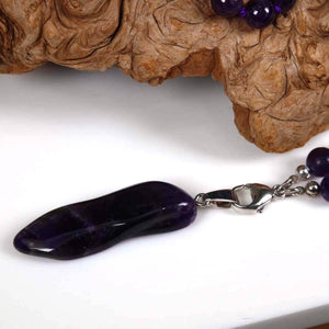 Mala Kette mit Amethyst Anhänger, zeigt den Amethystanhänger auf Holzuntergrund, ideal für Harmonie und Transformation.