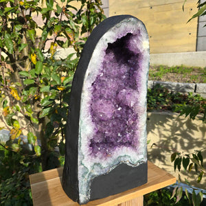 Amethyst druse geode displayed outdoors, unique piece number 114, extra dark AA quality, for meditation and interior decor