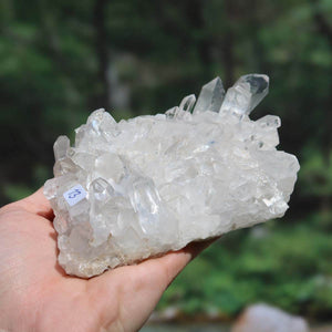 Raw Brazilian Bergkristall crystal cluster in hand, showcasing clear natural formations, product number 13.