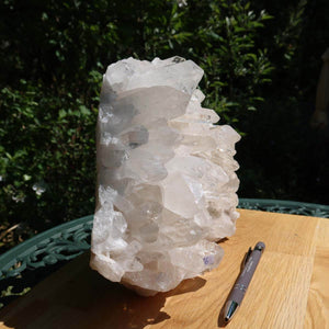 Bergkristall Stufe 1A mit großen Spitzen, 4.8kg, auf Holztisch im Freien, neben Stift, natürliche roher Quarz aus Brasilien.