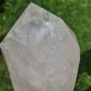 Glänzender Bergkristall Spitze auf grünem Hintergrund, perfekt als Raumdekoration oder für Meditationszwecke.