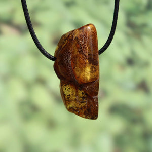 Natural amber pendant, 41mm, unique design with warm hues, hanging on a black cord.