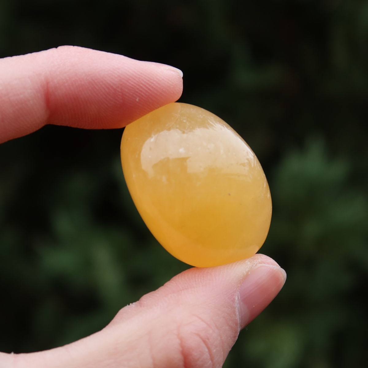 Calcit orange Handschmeichler - Selbstvertrauen und Positivität - Nr. 12, handgehalten und strahlend gelb.