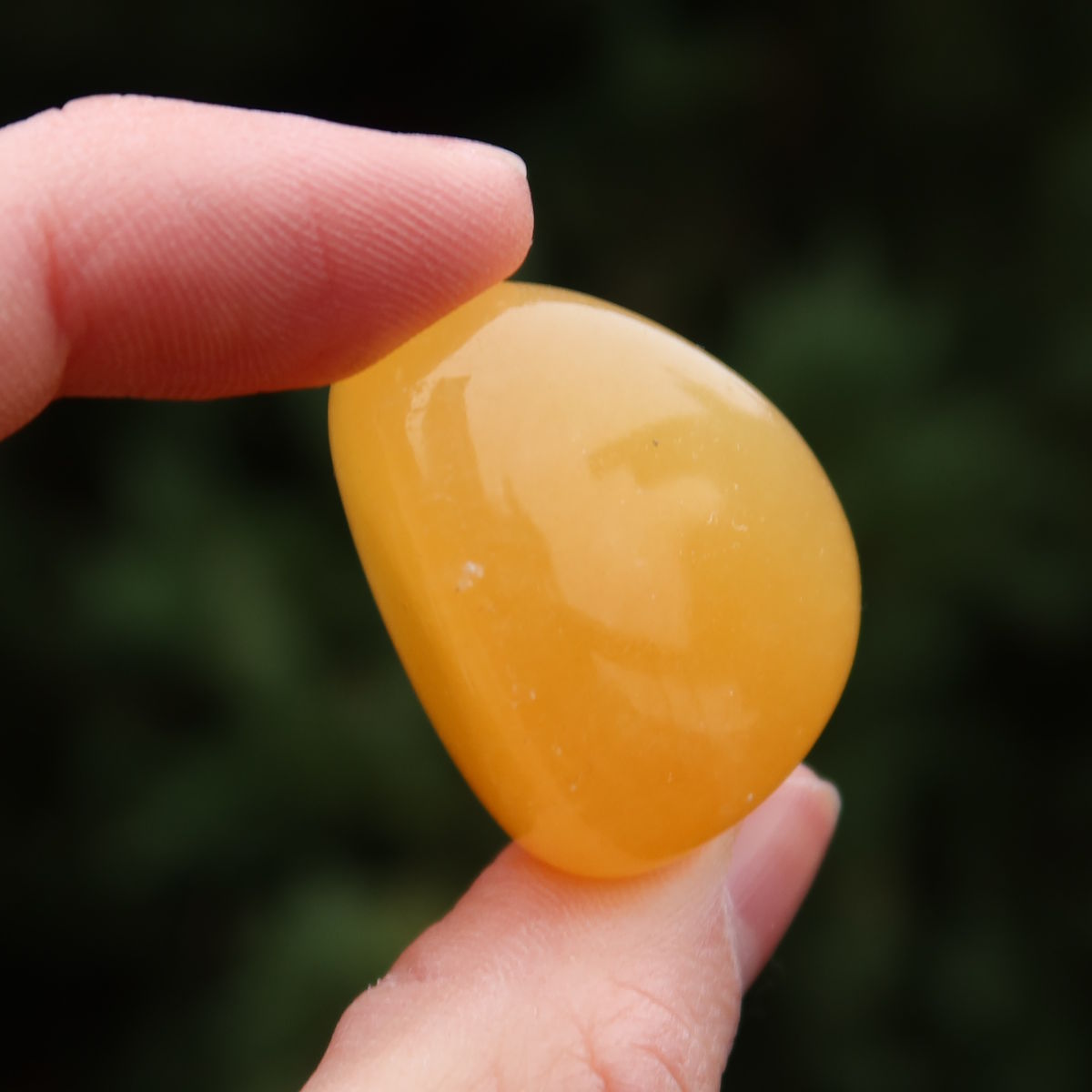 Calcit orange Handschmeichler - Selbstvertrauen und Positivität - Nr. 14 in der Hand, strahlend und warm.