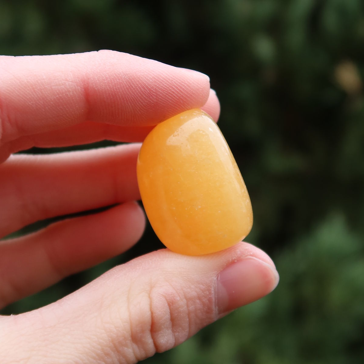 Calcit orange Handschmeichler - Selbstvertrauen und Positivität - Nr. 1 in der Hand, strahlende gelbe Farbe.