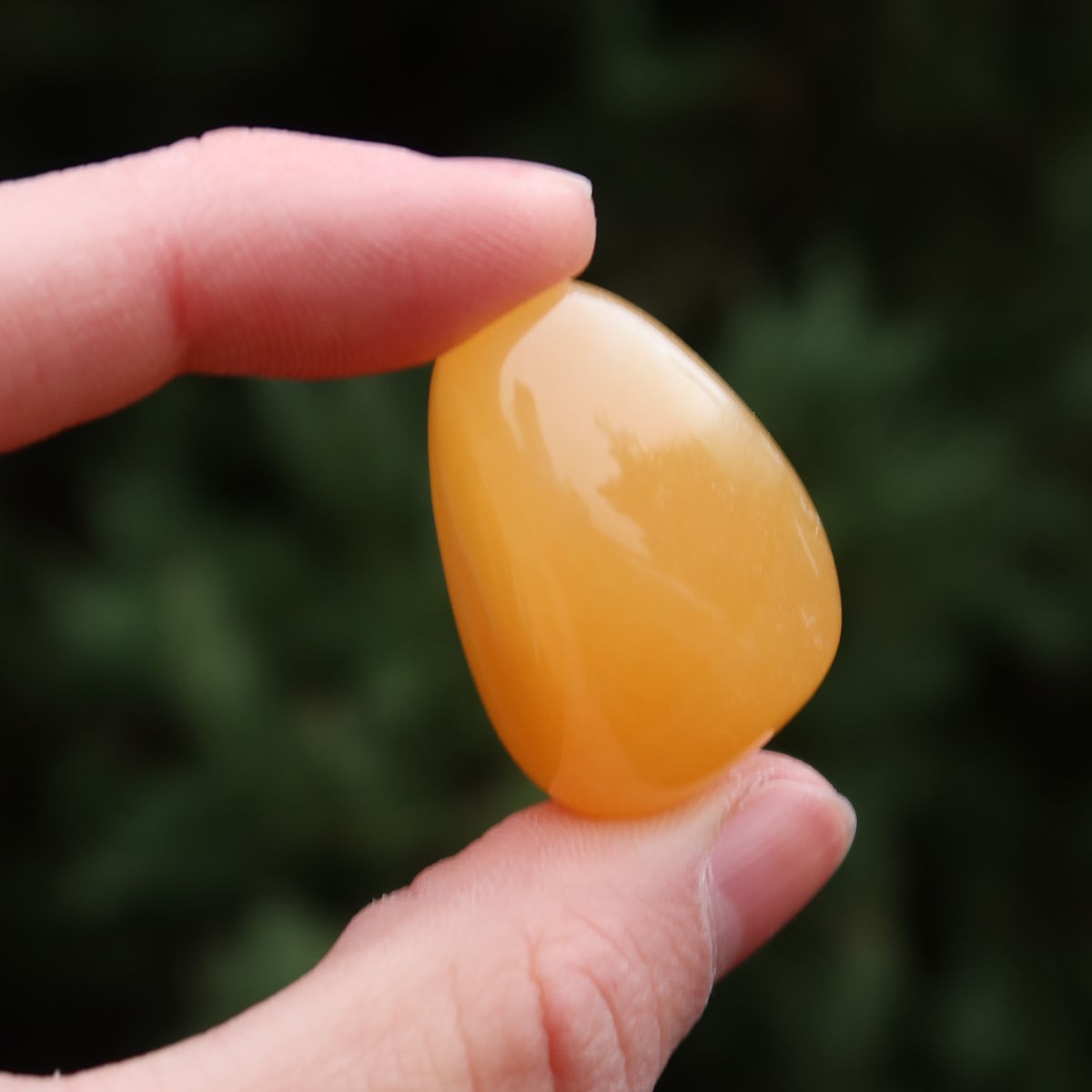 Calcit orange Handschmeichler - Selbstvertrauen und Positivität - Nr. 23 in hand gehalten, warme orange Farbe.