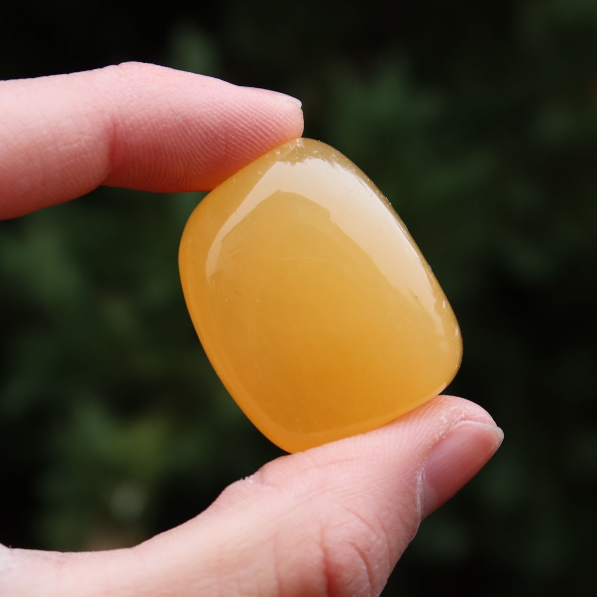 Calcit orange Handschmeichler - Selbstvertrauen und Positivität - Nr. 25 in handgehaltener Ansicht.