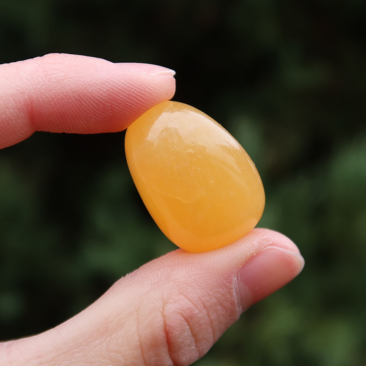 Calcit orange Handschmeichler - Selbstvertrauen und Positivität - Nr. 3 in der Hand, strahlend und warm.