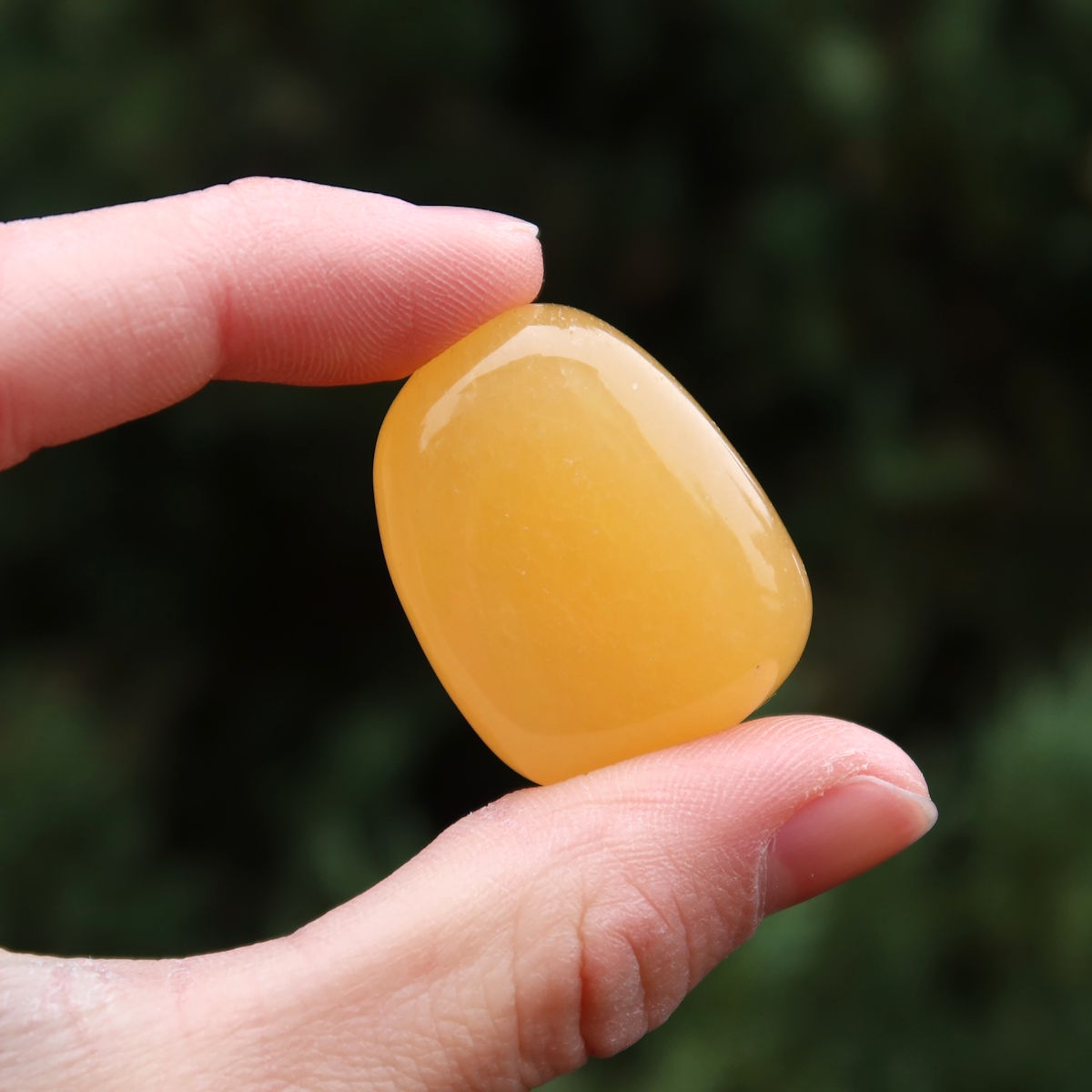 Calcit orange Handschmeichler - Selbstvertrauen und Positivität - Nr. 4 in Hand, strahlende orange Farbe.
