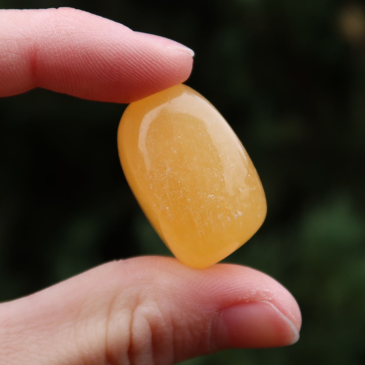 Calcit orange Handschmeichler - Selbstvertrauen und Positivität - Nr. 5 in der Hand, strahlende, sonnige Farbe.