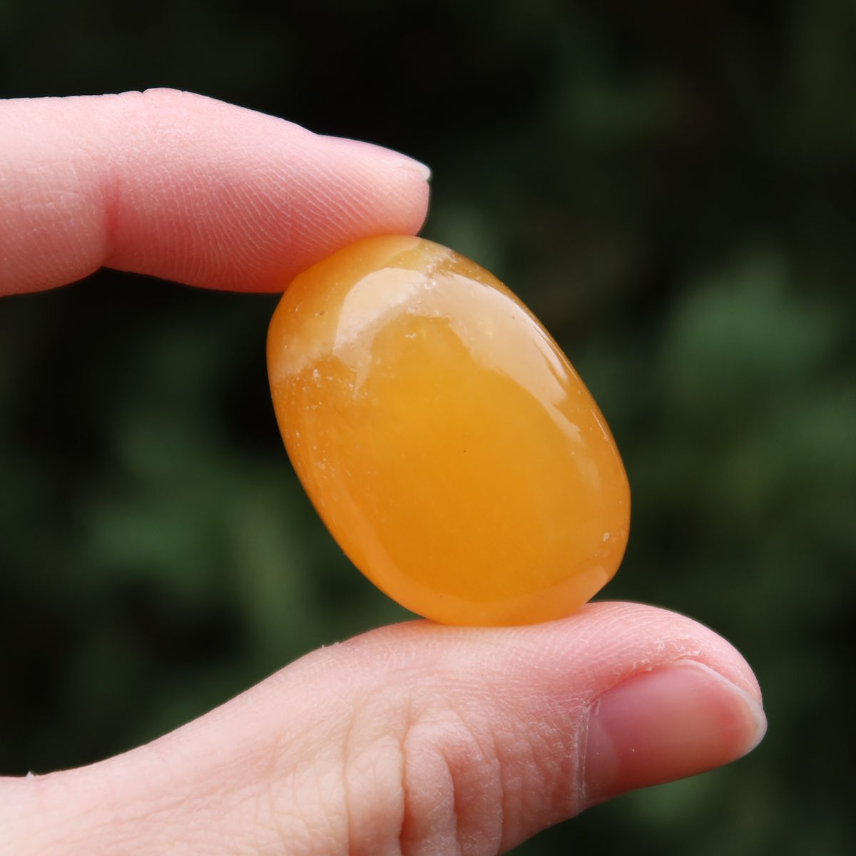 Calcit orange Handschmeichler - Selbstvertrauen und Positivität - Nr. 7 in Hand, strahlend und warm.