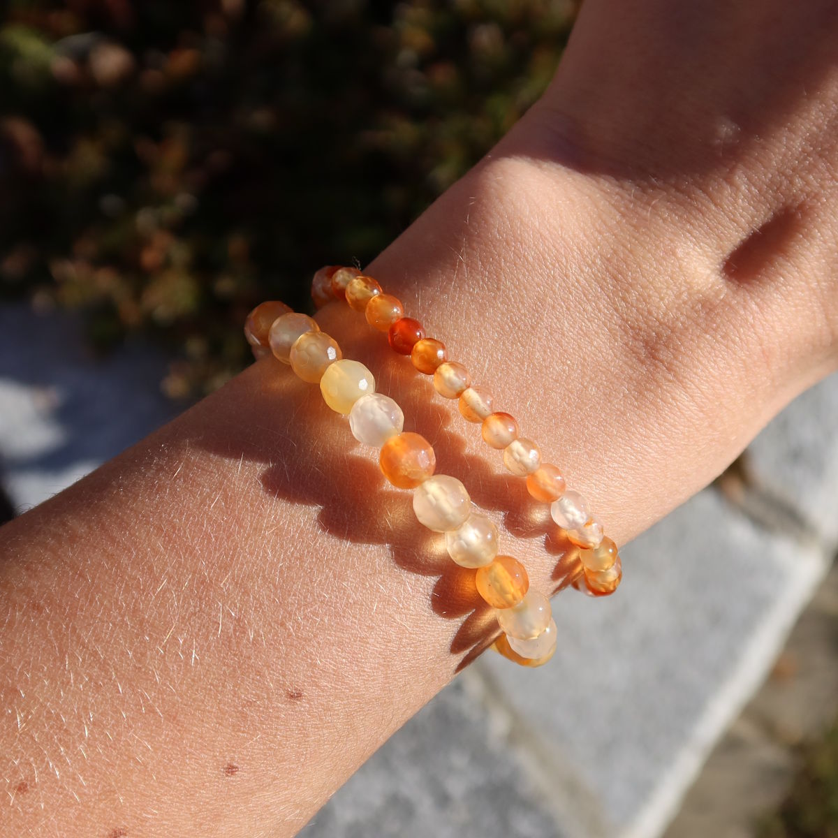 Karneol facettiert Edelstein Armband - 1 Stück - in Varianten 4-6 oder 8mm, getragen am Handgelenk, zeigt orangefarbene Perlen.