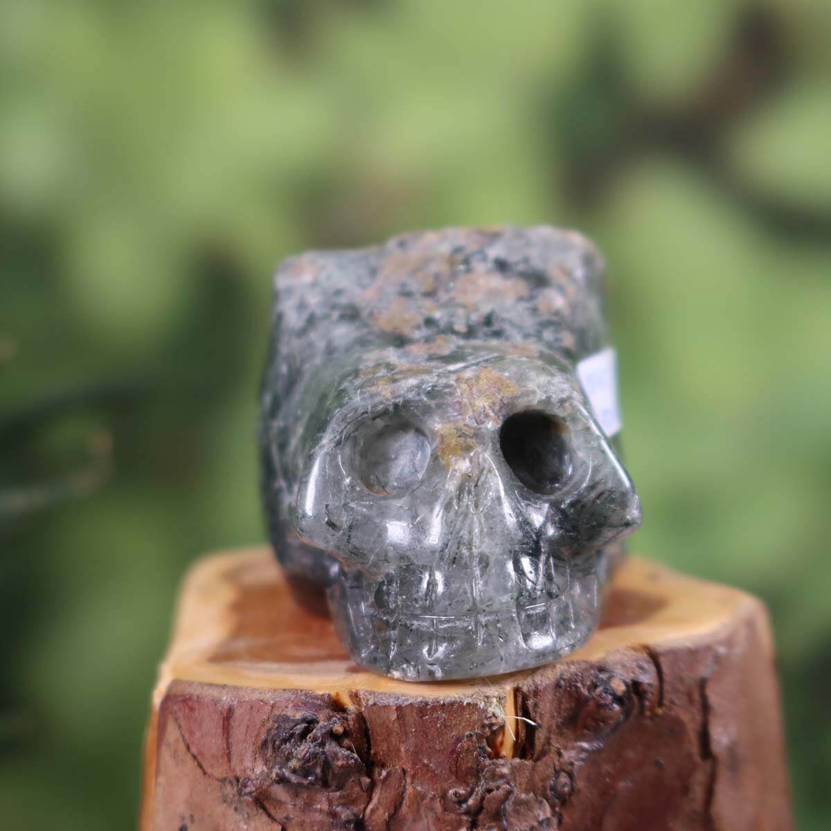 Handcrafted Actinolite Quartz Crystal Skull in Unique Shape, 9x5 cm, Collector's Item, held in hand against a green background.