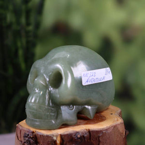 Handcrafted green aventurine crystal skull, unique shape, collector's item, #323, on a wooden stand, minerals and gemstones.