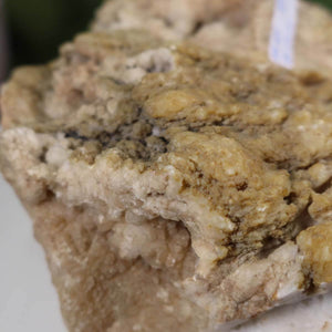 Close-up of a raw calcite crystal with rough edges and a mix of earthy colors, suitable for crystal enthusiasts and collectors.