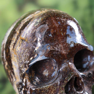 Close-up of handcrafted large crystal skull made from natural gemstone, showcasing unique colors and details.