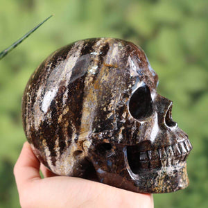 Handcrafted large crystal skull made from natural stone, approximately 12x9 cm, unique gemstone with distinctive patterns.