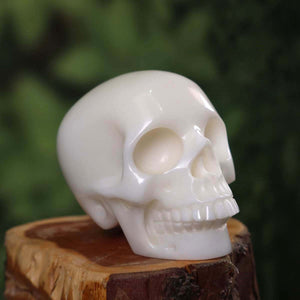 Handcrafted crystal skull made of natural stone on wooden base, 7x6 cm unique gemstone carving