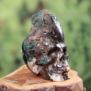 Handcrafted unique garnet uvarovite crystal skull sculpture on wooden base, 5x6 cm, collectible piece with intricate detailing.