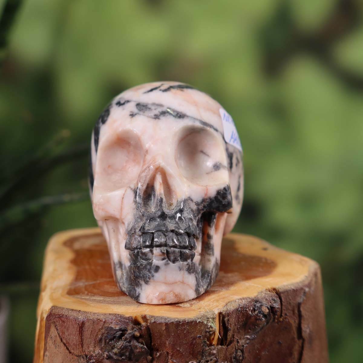 Handcrafted marble crystal skull with unique patterns, measuring 7x5 cm, displayed on a wooden surface.