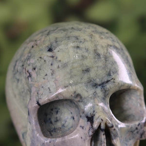 Serpentin Kristall Schädel handgefertigt - Skull - 12x10 cm Nr. 67, Nahaufnahme des grünen Kristalls mit feinen Details.