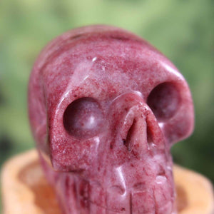 Handcrafted Thulite Crystal Skull, unique design, collectible, 7x6 cm, intricately carved gemstone.