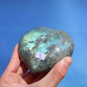 Labradorit Edelstein Herz in Hand, zeigt blau-grünes Schimmern, Unikat Nr. 9, zur Entspannung und Kreativitätsstärkung.