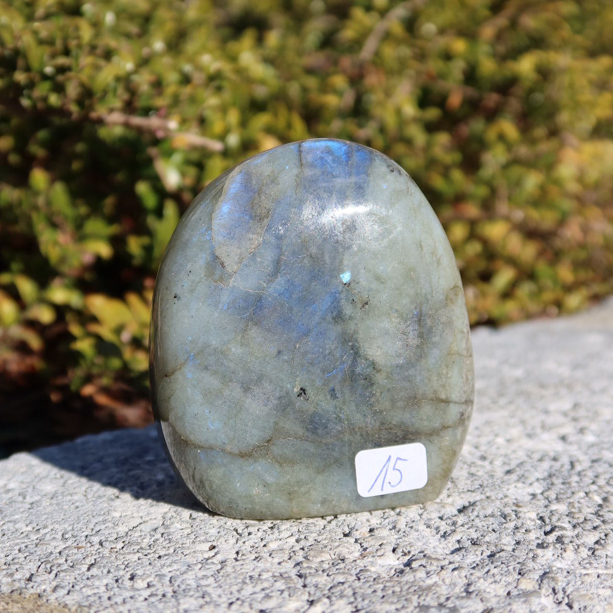 Labradorit Freiform poliert - 7x6cm - Intuition und Kreativität Nr.15 auf grauem Untergrund.