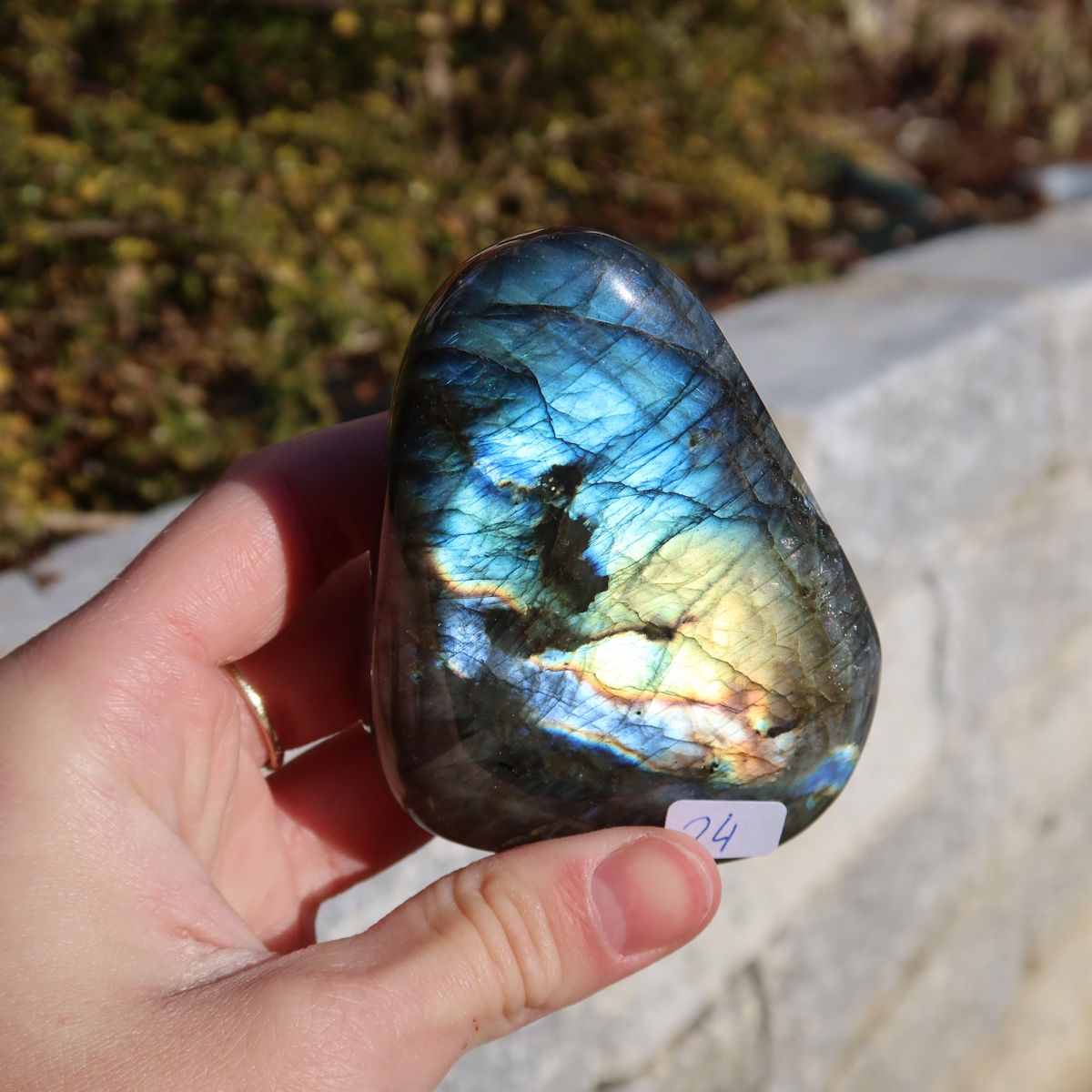 Labradorit Freiform poliert - 7x6cm - Intuition und Kreativität Nr.24 in der Hand mit charakteristischem Farbspiel.