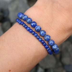 Two Lapislazuli 1A Edelstein Armband - 1 Stück - in Varianten 4-6-8 oder 10mm on wrist showcasing the stone's vibrant blue color.