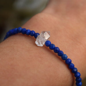 Handmade lapislazuli and Herkimer diamond bracelet on wrist, featuring deep blue faceted stones and a sparkling central Herkimer quartz.