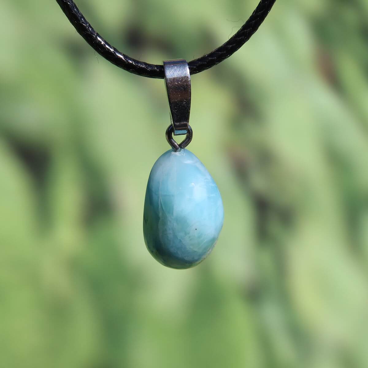 Larimar gemstone pendant with silver bail on a black cord, unique design from the Dominican Republic.