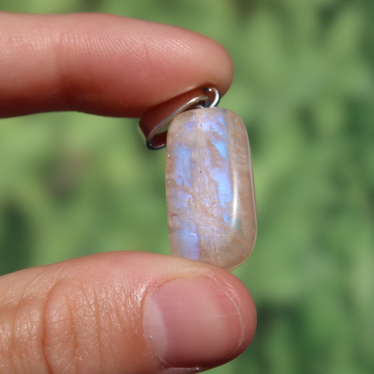 1A Qualität Mondstein Anhänger - Weiblichkeit und Intuition - UNIKAT Nr. 9 in Nahaufnahme, funkelt sanft blau und weiß im Licht.