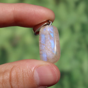 1A Qualität Mondstein Anhänger - Weiblichkeit und Intuition - UNIKAT Nr. 9 in Nahaufnahme, funkelt sanft blau und weiß im Licht.