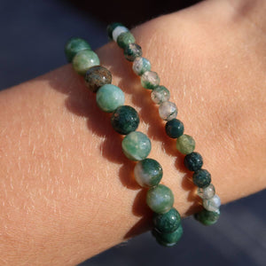 Zwei grüne facettierte Moosachat Armbänder in verschiedenen Größen auf einem Handgelenk, zeigen natürliche Muster und Farben.