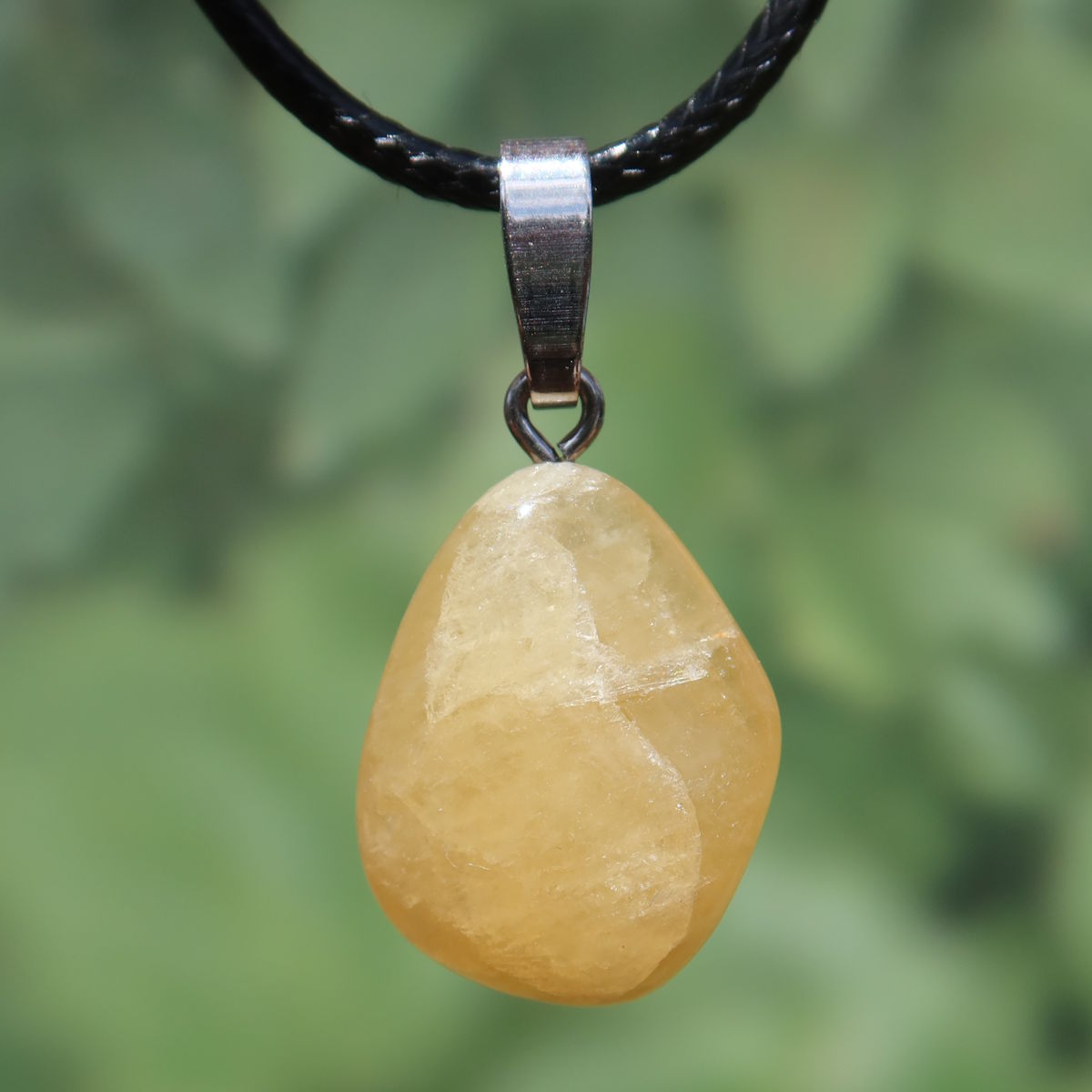 Calcit orange Anhänger - Selbstvertrauen und Positivität - Nr. 25 mit strahlend orangem Mineral auf Lederkette.