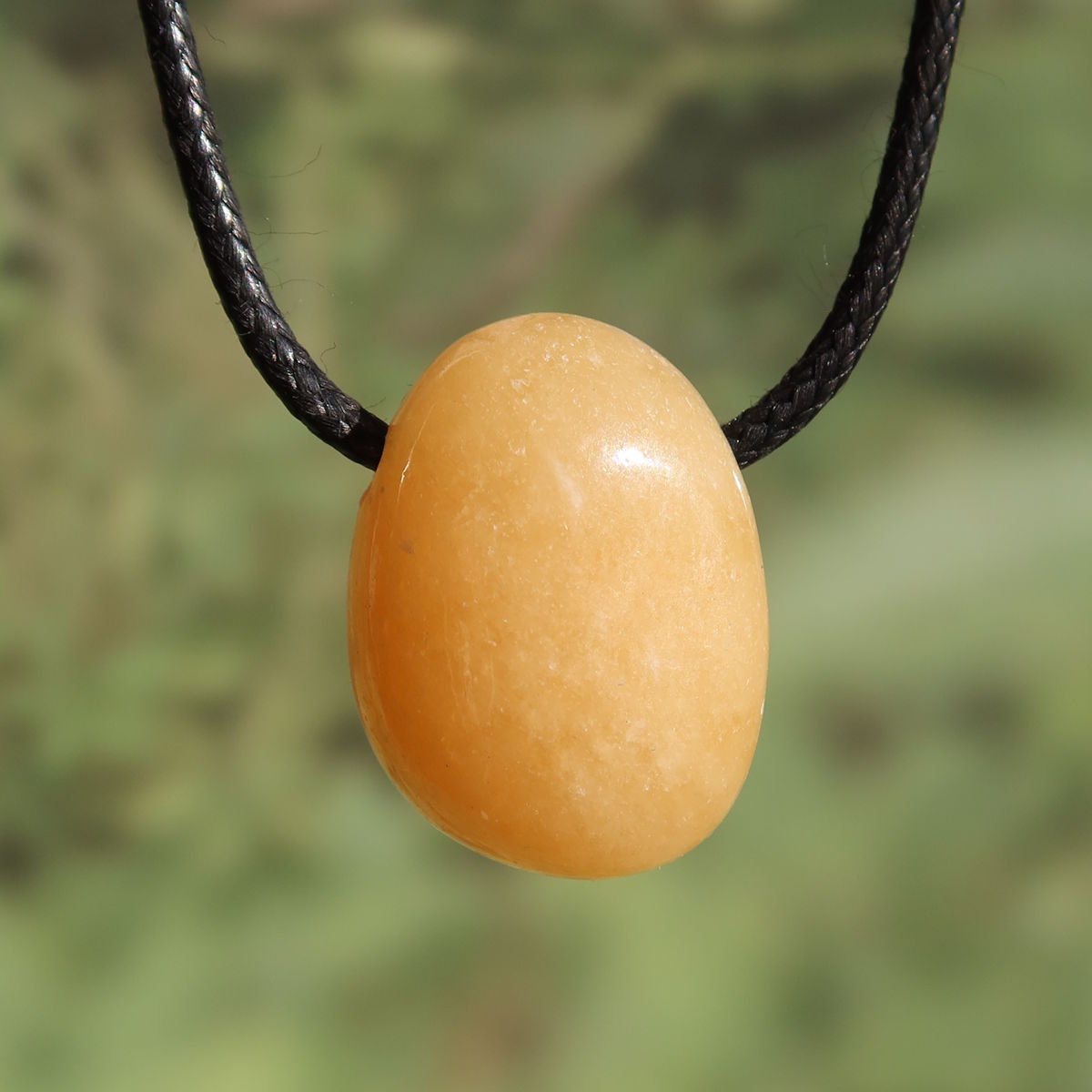 Calcit orange gebohrt - Selbstvertrauen und Positivität - Nr. 12 auf einem schwarzen Halsband
