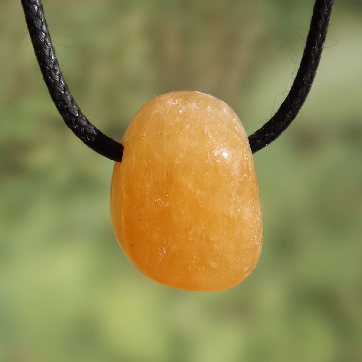 Calcit orange gebohrt - Selbstvertrauen und Positivität - Nr. 15 auf schwarzem Halsband