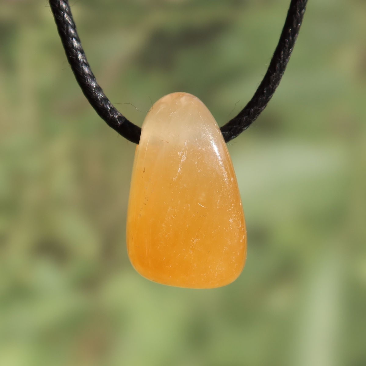 Calcit orange gebohrt - Selbstvertrauen und Positivität - Nr. 2 auf einer schwarzen Kette, strahlende orange Farbe.